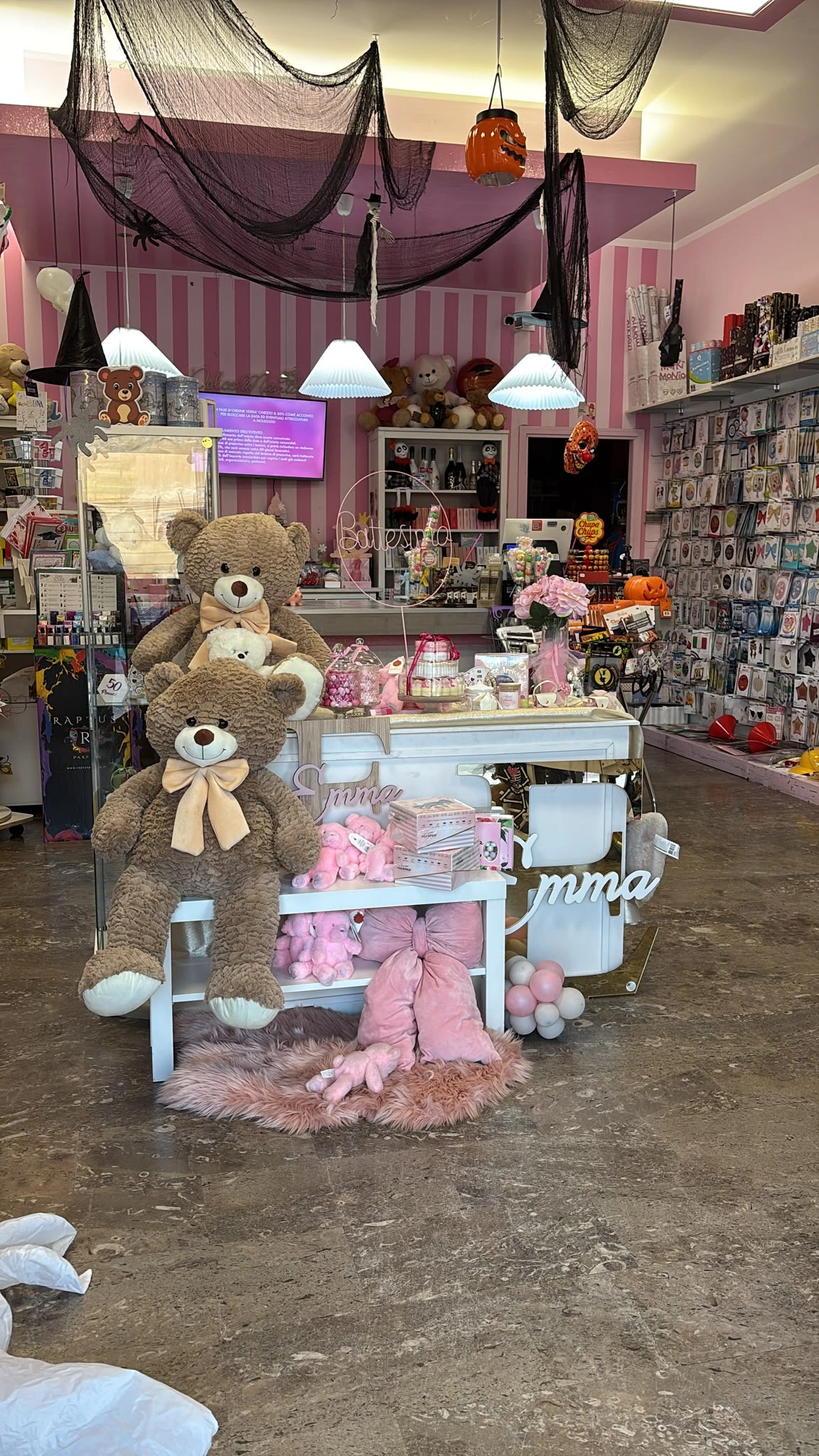 Esposizione nel negozio con peluche, dettagli rosa e articoli per feste
